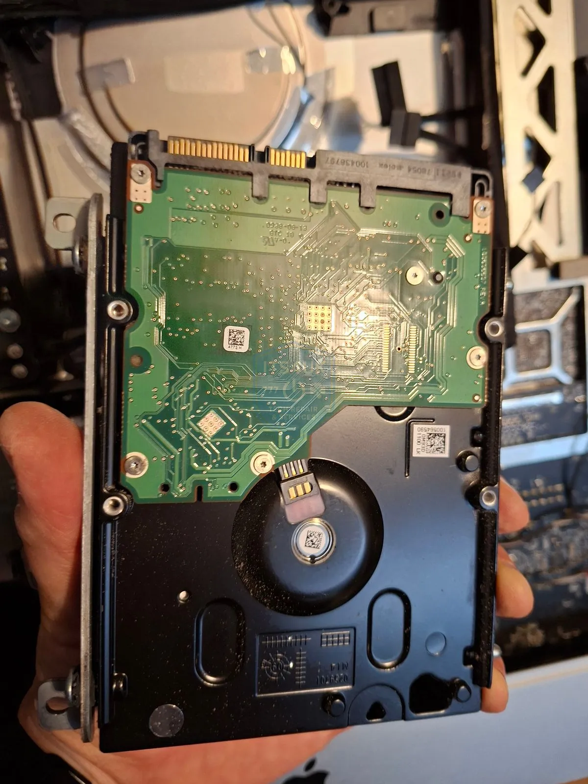 Technician holding a hard drive for inspection during the assessment stage